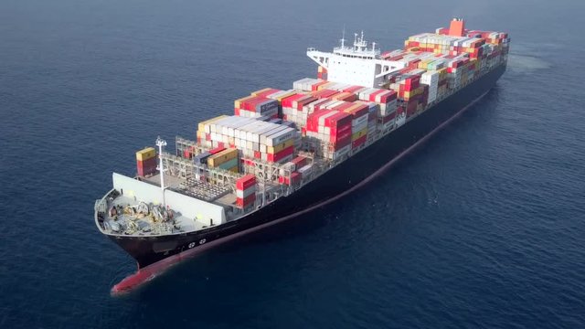 Container ship at sea - Aerial footage of a ULCV (Ultra large container vessel) loaded with various container brands.