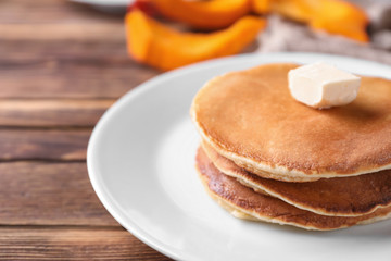Stack of hot pumpkin pancakes with butter on plate