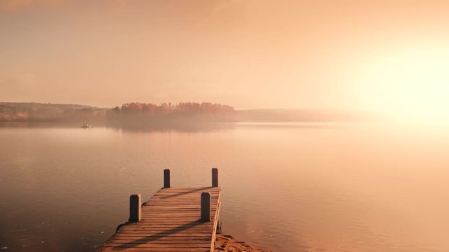 Boot mit Steg bei Sonnenaufgang im Morgenrot