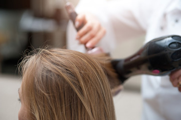 Naklejka premium Close up of woman and hairdresser with a hairdryer