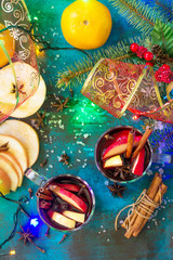 Christmas Mulled Wine or Sangria with Spices. Two glasses of hot mulled wine with Apple and spices on blue slate table. Top view flat lay background.