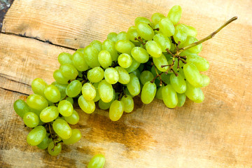 juicy green grape on a rustic wooden board