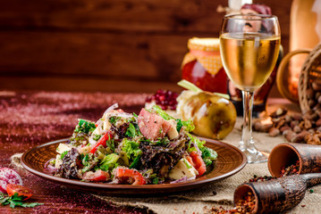 vegetable salad with tomatoes, cheese and bell peppers on a brown plate and a glass of white wine on a dark wooden background. beautiful composition. Georgian cuisine. close-up