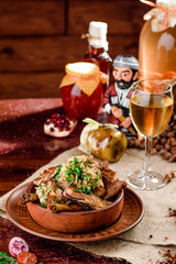 national Georgian cuisine. chicken thighs in a brown plate and a glass of white wine in a beautiful composition on a burlap on a wooden table. close-up. photo series