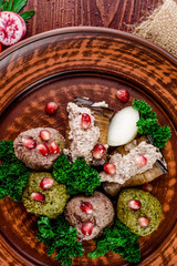 Georgian dish - phali of spinach and meat on a brown plate on a wooden background. close-up