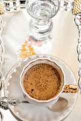 black coffee in a white cup on a silver tray