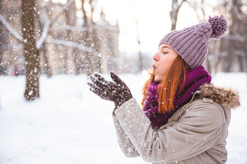 Happy redhead woman walking in winter park and enjoy the snow