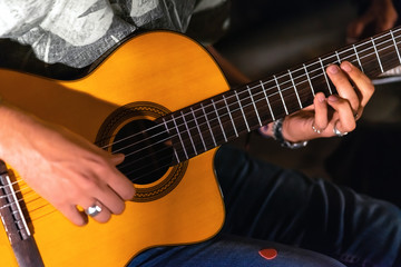 Man playing yellowe an acoustic guitar closeup