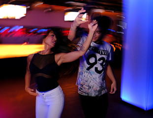 Pareja joven bailando salsa y bachata en una fiesta en club nocturno