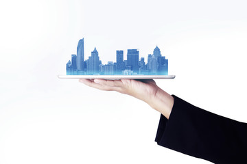 Creative image of business man is handling tablet and putting city blue skyline on it on white background isolate.
