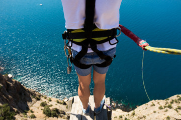 Rope jumping off a cliff with a rope in the water. The ocean. Sea. Mountain