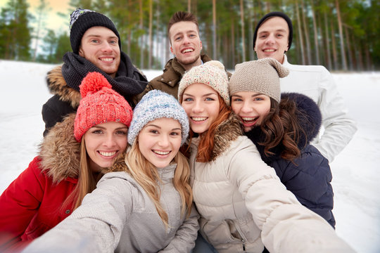 winter, friendship and people concept - group of friends taking selfie outdoors over natural background - Powered by Adobe
