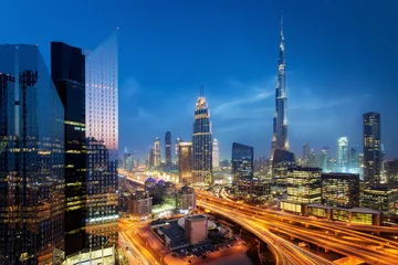 Foto op Canvas Beautiful aerial view to Dubai downtown city center lights skyline at night, United Arab Emirates. Long exposure light trails effect © Ivan Kurmyshov