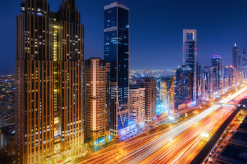 Fototapeta na wymiar Beautiful aerial view to Dubai downtown city center lights skyline at night, United Arab Emirates. Long exposure light trails effect