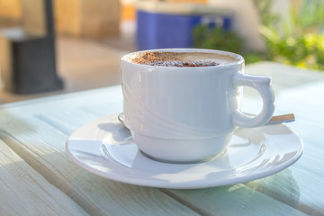 cup of cappuccino with latte art on wooden white table