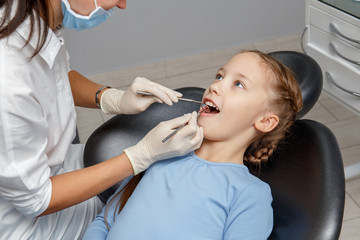 Child having dental check up by specialist in dentist office