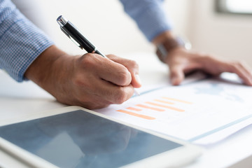 Closeup of man analyzing business data. Infographics and tablet computer. Marketing concept....