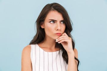 Displeased young woman posing isolated over blue background wall.