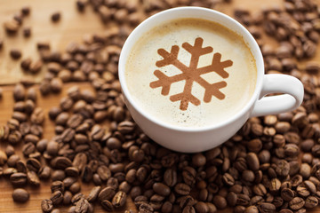 winter holidays and hot drinks concept - close up coffee cup with snowflake stencil picture and...