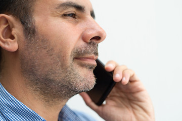 Closeup of serious business man talking on smartphone. Confident guy. Communication concept. Side view.