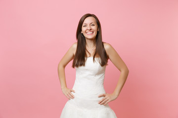 Portrait of joyful smiling bride woman in beautiful white wedding lace dress standing with arms...