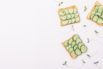 Flat lay decorative side frame of toasts with fresh cucumbers