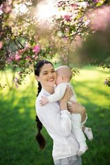 Obraz premium Portrait Beautiful Mother And Baby outdoors. Nature. Beauty Mum and her Child playing in Park