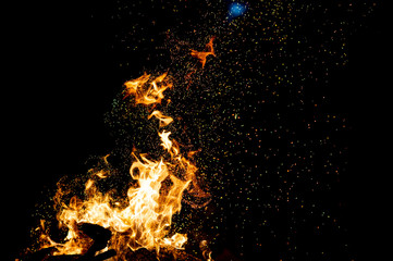 Burning woods with firesparks, flame and smoke. Strange weird odd elemental fiery figures on black background. Coal and ash. Abstract shapes at night. Bonfire outdoor on nature. Strenght of element.