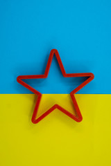 Cookie cutter star shape on blue and yellow background