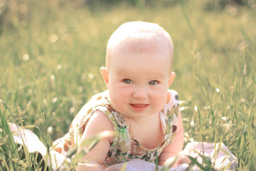 portrait of pretty baby on the lawn on a summer day