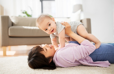 family and motherhood concept - happy smiling young asian mother with little baby at home