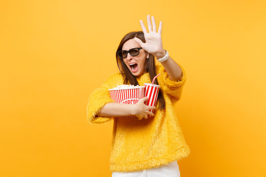 Scared Woman In 3d Imax Glasses Screaming Trying To Closing Screen By Palm Watching Movie Film Holding Popcorn Cup Of Cola Isolated On Yellow Background. People Sincere Emotions In Cinema, Lifestyle.