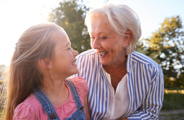 Grandmother Playing Game With Granddaughter In Summer Park