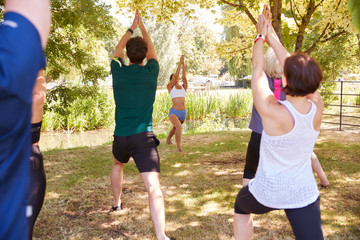 Fototapeta premium Female Instructor Leading Outdoor Yoga Class