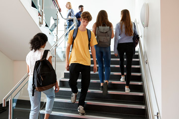 High School Students Walking On Stairs Between Lessons In Busy College Building