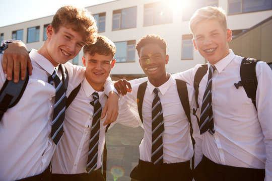 Portrait Of Smiling Male High School Students Wearing Uniform Outside College Building