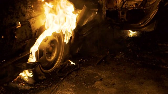 A wheel burns in a car at night, car tires burn, close-up