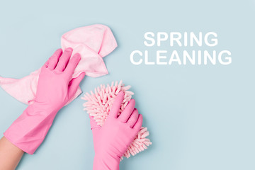 Female hands cleaning on blue background. Cleaning or housekeeping concept background. Copy space. ...