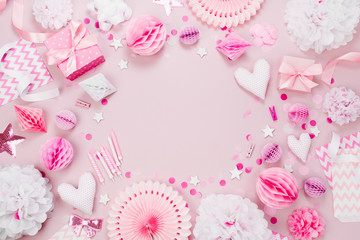 Frame made of Pink and white Paper Decorations, candy, hearts, gifts, confetti for Baby party. Flat lay, top view