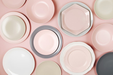 Plates and dishes for serving a festive table on pastel colors background. Flat lay, top view.