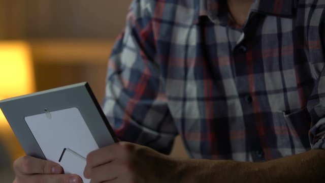 Sad man looking at photo of ex-girlfriend, regretting break-up, depression