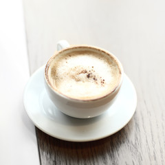 cappuccino Cup with foam on a wooden table in a cafe