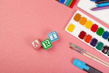 Art concept. School supplies and wooden alphabetical cubes