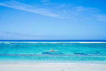 Obraz na płótnie Canvas A canoe paddling through the tropical ocean of Reunion island, a holiday paradise.