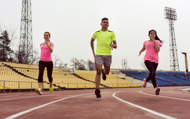 Obraz premium Young caucasian friends doing running practice on ground