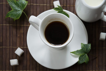 still life with coffee Cup and milkman on brown background.