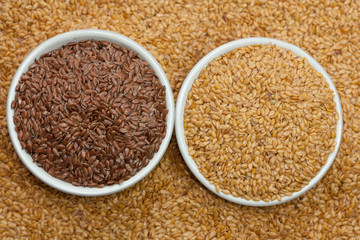 Brown and golden linseeds in a bowl.