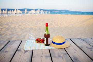 picnic near the sea-hat, wine, glasses strawberry