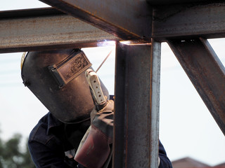 Welding work, worker with protective welding metal on construction