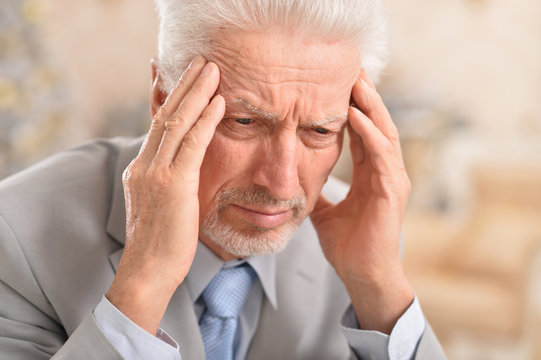Close up portrait of senior man with headache